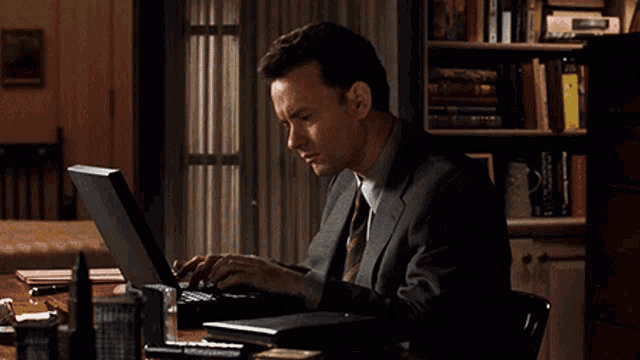 Tom Hank experiencing writer's block while using his laptop.
